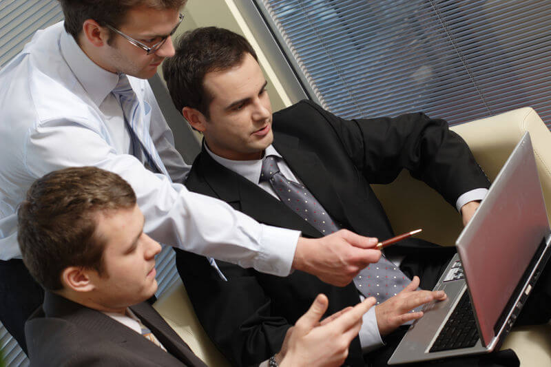Younger business owners talking about matters using a laptop; Business Owners and Asset Protection; Gardner and Overland Park, Kansas
